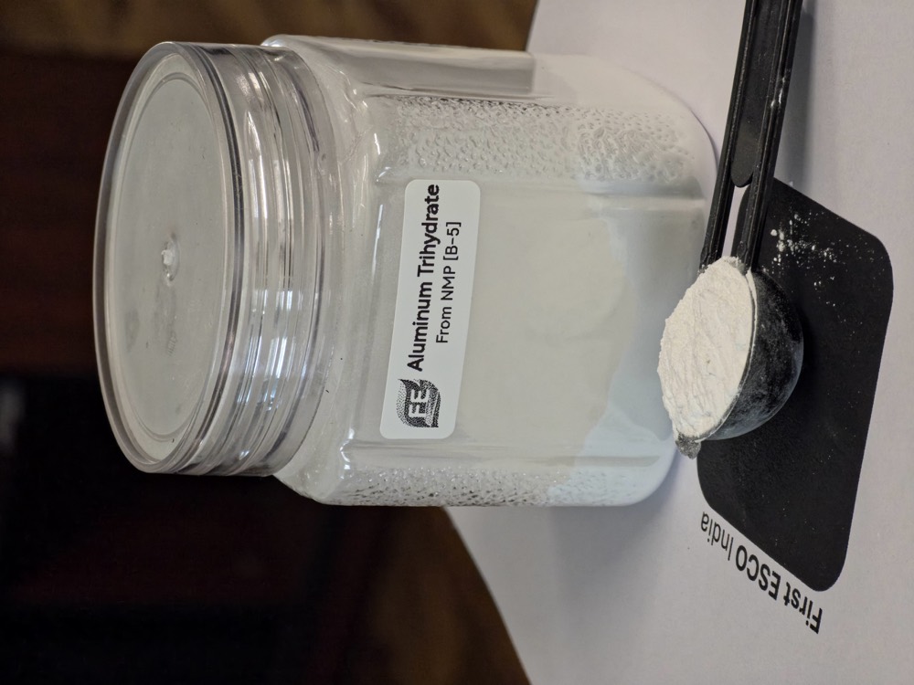 Aluminium trihydrate powder recovered from red mud, in a labelled specimen jar