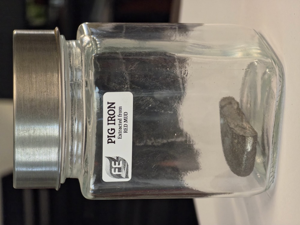 Pig iron ingot extracted from red mud, in a labelled specimen jar