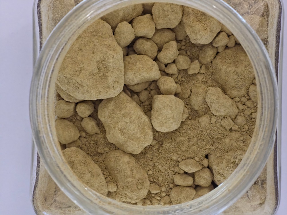 Jarosite waste sample: ochre-yellow residue from zinc refining in a jar